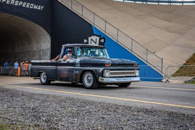 Lebanon, TN - May 14, 2022: Wide angle front corner view of a 1966 Chevrolet C10 Pickup Truck driving on a road leaving a local car show.