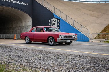 Lebanon, TN - May 14, 2022: Wide angle front corner view of a 1967 Chevrolet Chevelle 300 Deluxe 2 Door Hardtop driving on a road leaving a local car show.