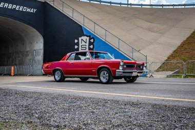 Lebanon, TN - May 14, 2022: Wide angle front corner view of a 1965 Pontiac GTO Hardtop Coupe driving on a road leaving a local car show.