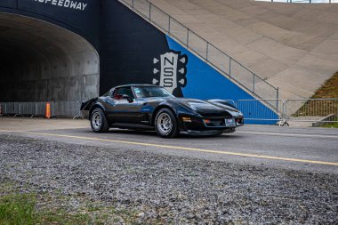 Lebanon, TN - May 14, 2022: Wide angle front corner view of a 1980 Chevrolet Corvette Hardtop Coupe driving on a road leaving a local car show.