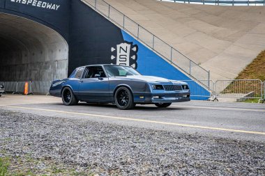 Lebanon, TN - May 14, 2022: Wide angle front corner view of a 1985 Chevrolet Monte Carlo Coupe driving on a road leaving a local car show.