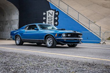 Lebanon, TN - May 14, 2022: Wide angle front corner view of a 1970 Ford Mustang Fastback Mach 1 driving on a road leaving a local car show.