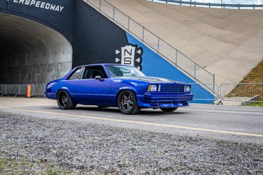 Lebanon, TN - May 14, 2022: Wide angle front corner view of a Customized 1978 Chevrolet Malbu Hardtop Coupe driving on a road leaving a local car show.