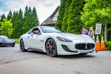 Highlands, NC - June 10, 2022: Low perspective front corner view of a 2017 Maserati GranTurismo Sport Hardtop Coupe leaving  a local car show.
