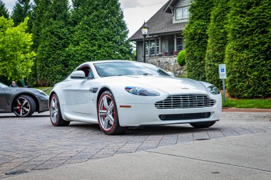 Highlands, NC - June 10, 2022: Low perspective front corner view of a 2011 Aston Martin V8 Vantage N420 Hardtop Coupe leaving a local car show.