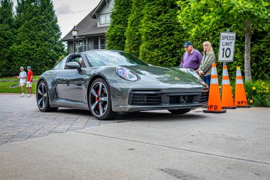 Highlands, NC - June 10, 2022: Low perspective front corner view of a 2021 Porsche 911 Targa 4S Coupe leaving  a local car show.