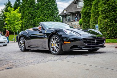 Highlands, NC - June 10, 2022: Low perspective front corner view of a 2011 Ferrari California Convertible leaving  a local car show.