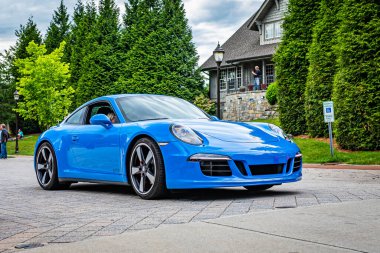 Highlands, NC - June 10, 2022: Low perspective front corner view of a 2016 Porsche 911 Carrera GTS Club Coupe leaving a local car show.