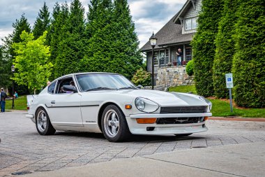 Highlands, NC - June 10, 2022: Low perspective front corner view of a 1972 Datsun 240Z Hardtop Coupe leaving a local car show.