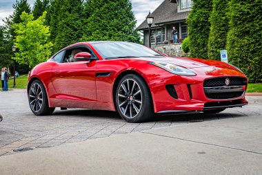 Highlands, NC - June 10, 2022: Low perspective front corner view of a 2014 Jaguar F Type V8 R Hardtop Coupe leaving a local car show.
