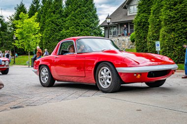 Highlands, NC - June 10, 2022: Low perspective front corner view of a 1969 Lotus Elan S4 Hardtop Coupe leaving a local car show.