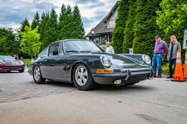Highlands, NC - June 10, 2022: Low perspective front corner view of a 1966 Porsche 911 Hardtop Coupe leaving a local car show.
