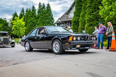 Highlands, NC - June 10, 2022: Low perspective front corner view of a 1988 BMW M6 Hardtop Coupe leaving a local car show.