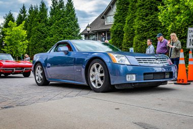 Highlands, NC - June 10, 2022: Low perspective front corner view of a 2004 Cadillac XLR Hardtop Coupe leaving a local car show.