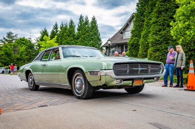 Highlands, NC - June 10, 2022: Low perspective front corner view of a 1969 Ford Thunderbird Landau Sedan leaving a local car show.
