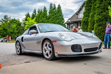 Highlands, NC - June 10, 2022: Low perspective front corner view of a 2002 Porsche 911 Turbo Tiptronic Coupe leaving a local car show.