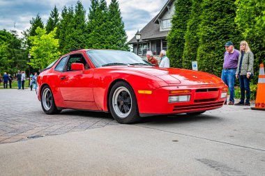 Highlands, NC - June 10, 2022: Low perspective front corner view of a 1986 Porsche 944 Turbo Hardtop Coupe leaving a local car show.