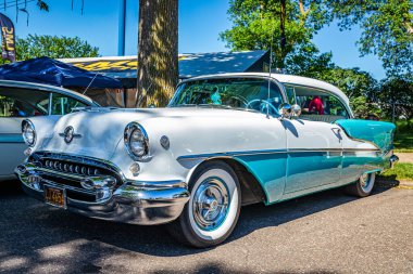 Falcon Heights, MN - June 17, 2022: Low perspective front corner view of a 1955 Oldsmobile Super 88 Holiday Coupe at a local car show.