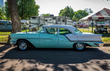 Falcon Heights, MN - 18 Haziran 2022: Yerel bir otomobil fuarında 1957 Oldsmobile Super 88 Holiday Sedan 'ın düşük perspektifli yan görüntüsü.