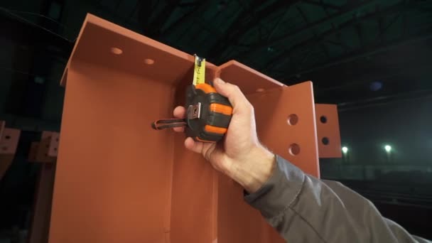 Een arbeider meet een stuk metaal. meetlint in beweging close-up — Stockvideo