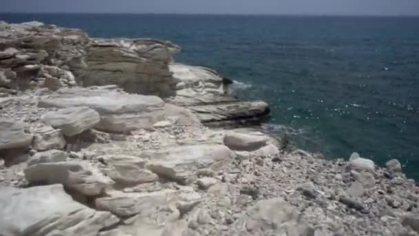 近视的小海浪冲破岩石在阳光下。海洋和温暖的夏天 — 图库视频影像