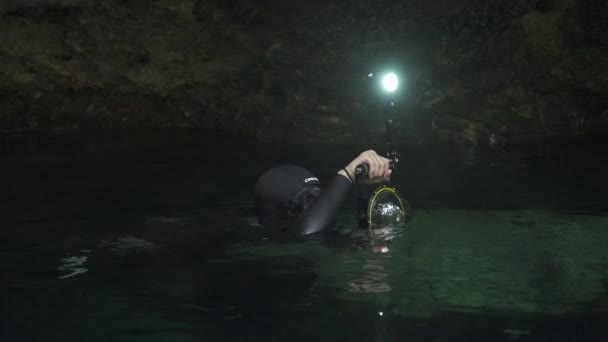 Photographe sous-marin en combinaison de plongée avec caméra sous-marine et lumières — Video
