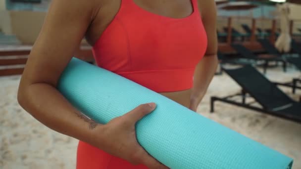 Kadının kumsalda Sport Mat in Hands ile dikilirken yakın çekimi. Yavaş çekim — Stok video