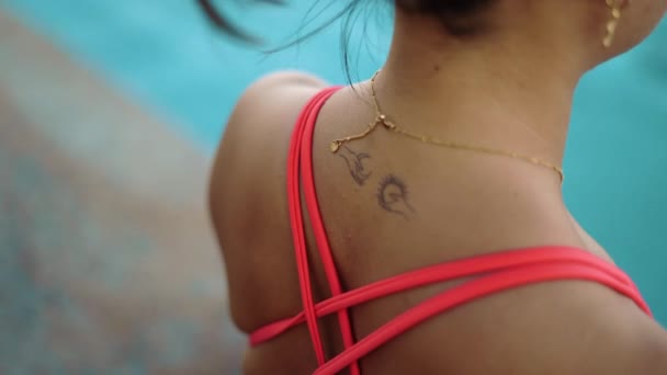 Młoda atrakcyjna kobieta zbliżyć tatuaż, robi jogi poza w pobliżu basenu — Wideo stockowe