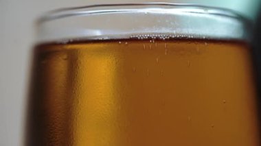 Bardakta bira. Köpük hareket ediyor. - Alkol. Camdaki kabarcıklar. Kapat.