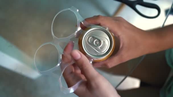 Kunststoffringe für die Verpackung von Bier weibliche Hände werden aus der Eisendose entfernt. — Stockvideo