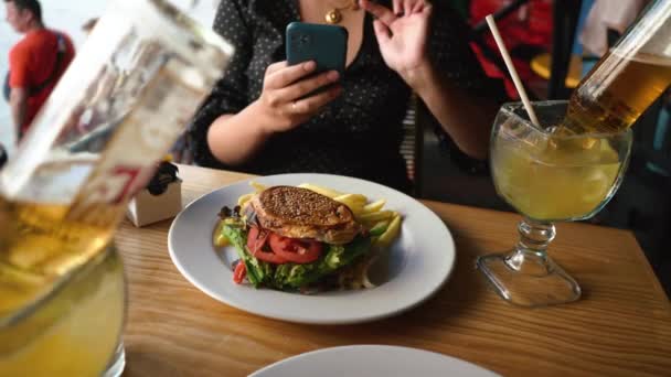 Foto maken van Fast food hamburger met koude cocktaildrank in glas — Stockvideo
