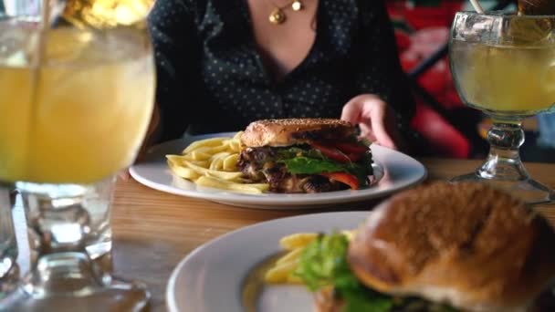 Plaque tournante fille avec hamburger Fast Food et boisson cocktail froid en verre — Video