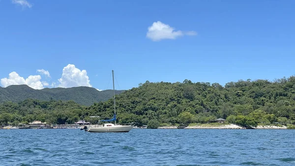 Okyanusta, mavi gökyüzü ve Hong Kong 'da bulutları olan yatay bir yelkenli.