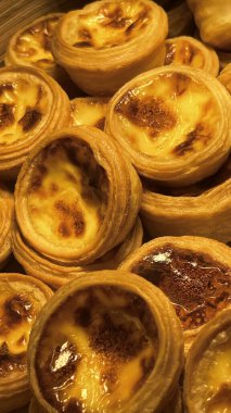 A lot of the yellow portuguese egg crust tarts close up