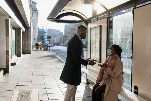 Duas Pessoas Vestindo Revestimentos Faciais Espera Ônibus Conversando Gesticulando Com — Fotografia de Stock