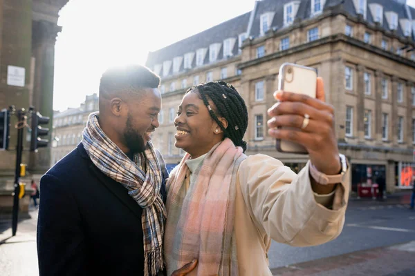 Alegre Pareja Sonriendo Cara Cara Ciudad Mujer Sosteniendo Teléfono Tomando — Foto de Stock