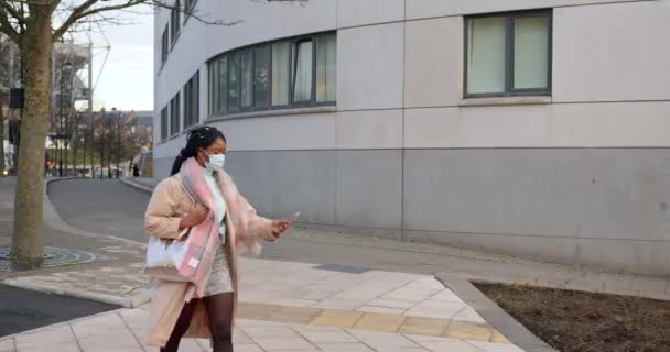 Žena Obličejem Pokrytí Pomocí Mobilního Telefonu Když Jde Kolem Budovy — Stock video