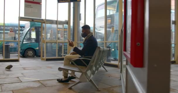 Uomo Che Indossa Maschera Viso Seduto Sulla Panchina Nel Terminal — Video Stock