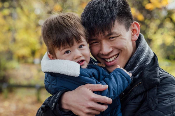 Young Man Carrying His Baby Boy His Arms While Standing — стоковое фото