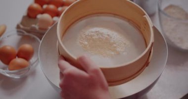 Sifting flour in Strainer. Woman Preparing Ingredients for baking croissants.