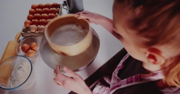 Женщина на кухне наливает муку в миску крупным планом — стоковое видео