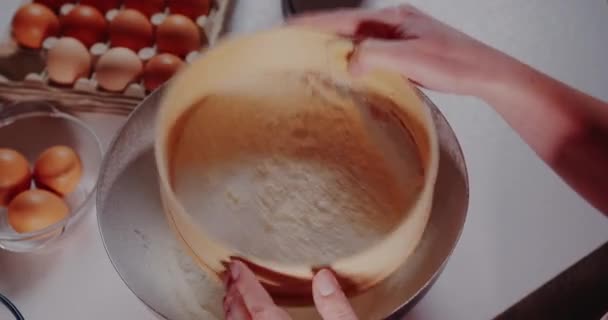 Mulher na cozinha derrama farinha em uma tigela close-up — Vídeo de Stock