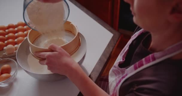 Mujer en la cocina vierte harina en un tazón de cerca — Vídeos de Stock