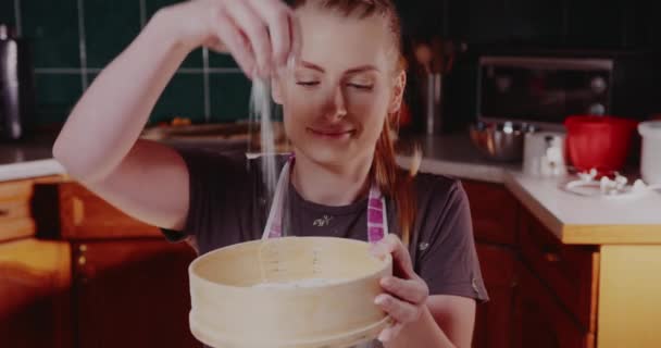 Mulher na cozinha derrama farinha em uma tigela close-up — Vídeo de Stock