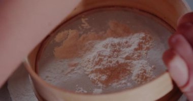 Sifting flour in Strainer. Woman Preparing Ingredients for baking croissants.