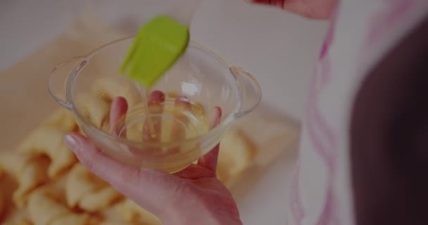 Frau macht leckere Croissants auf Tisch in Küche — Stockvideo