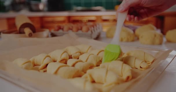 Kvinna borsta croissanter med ägg — Stockvideo