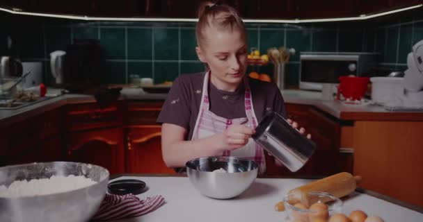 Žena tahá mouku přes síto v kuchyni a peče croissanty. — Stock video