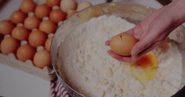 Samičí ruka láme čerstvé kuřecí vejce do misky. — Stock video