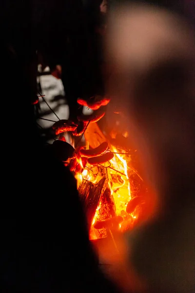 Pieczenie kiełbasy nad ogniem w zimie — Zdjęcie stockowe